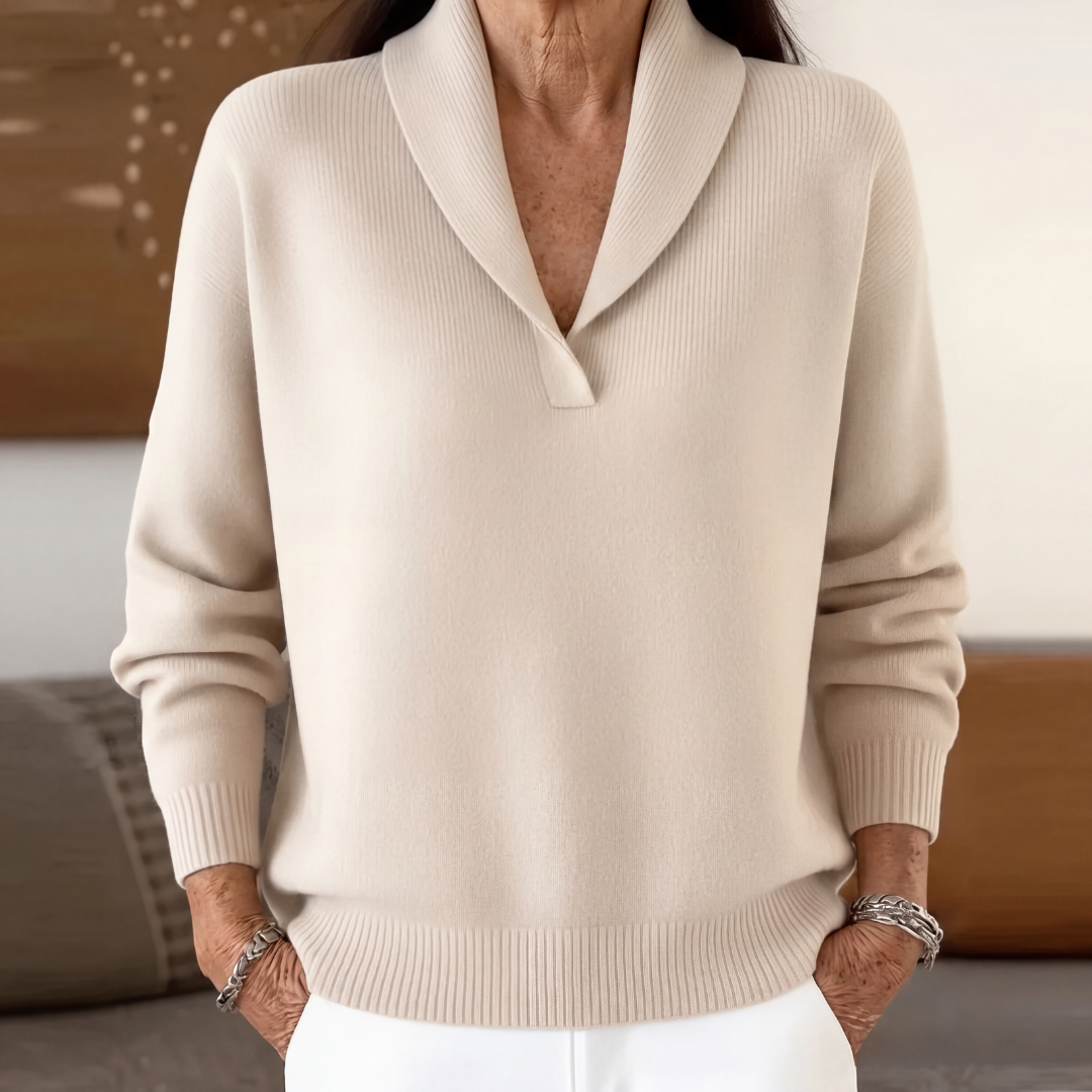 Cream shawl collar v neck sweater worn with white pants, front view