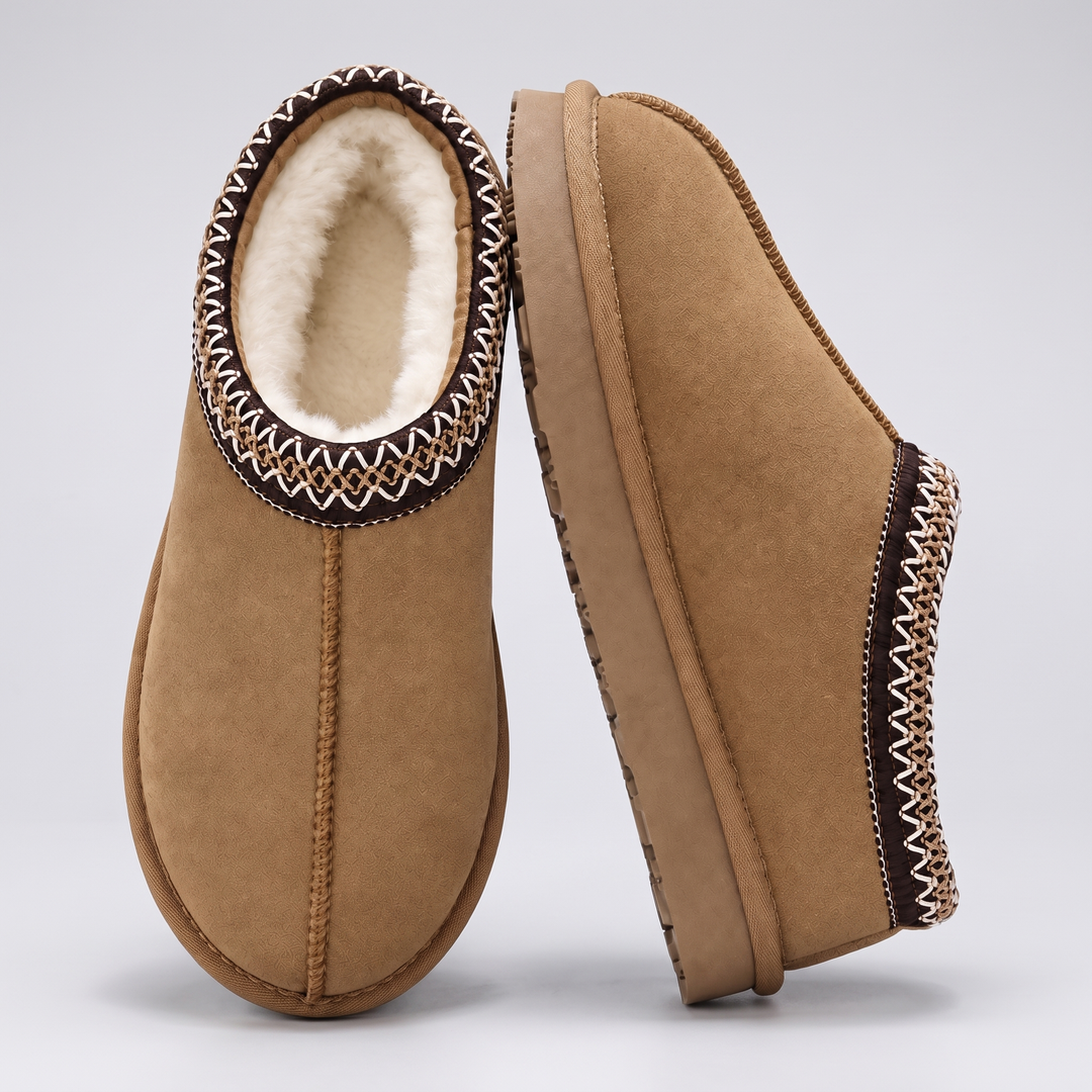 Pair of tan slippers with cream lining and embroidered collar, one standing on its side