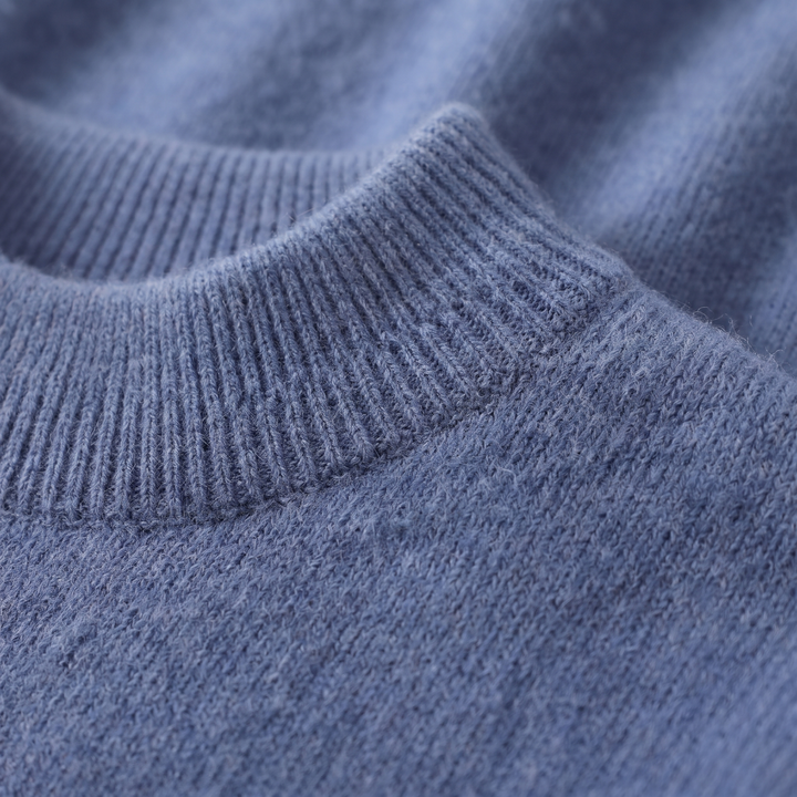 Close-up of the blue mock neck collar and fine knit texture