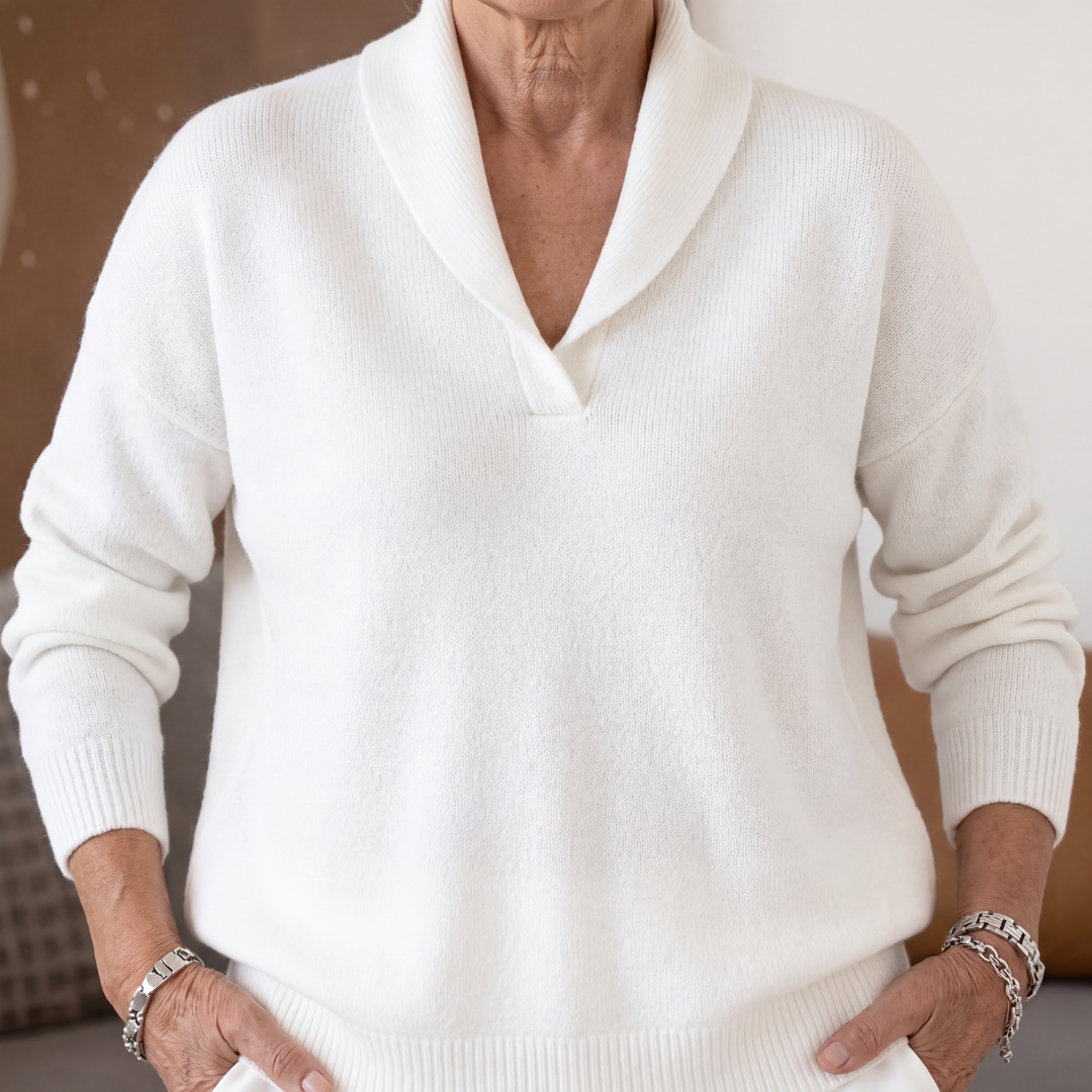 White v neck sweater with shawl collar, hands resting on hips