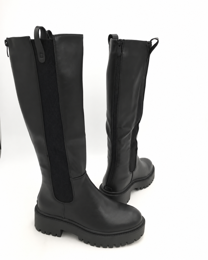 Pair of black knee high boots with elastic back panel and chunky sole