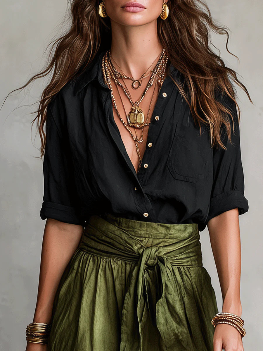 Close-up of the black button shirt and tied waist of the olive skirt