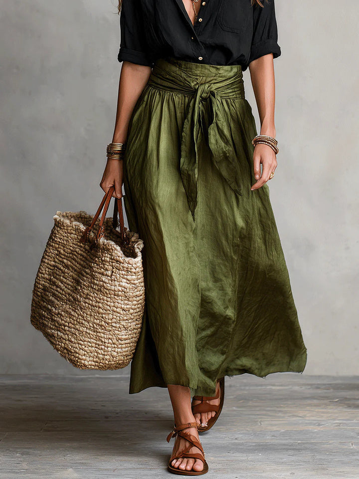 Front view of the olive midi skirt and black shirt styled with a woven tote