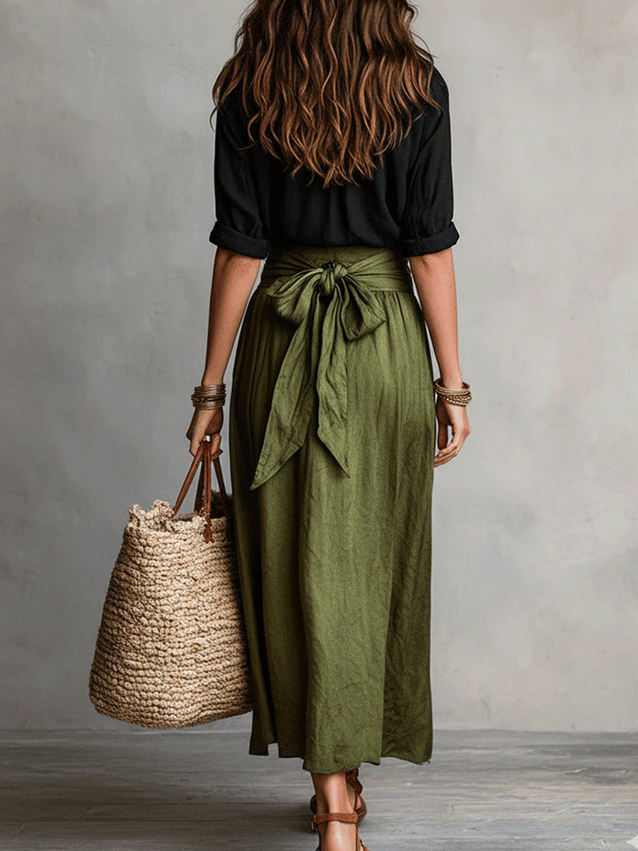Back view of the black shirt and olive wrap skirt with a bow tie waist