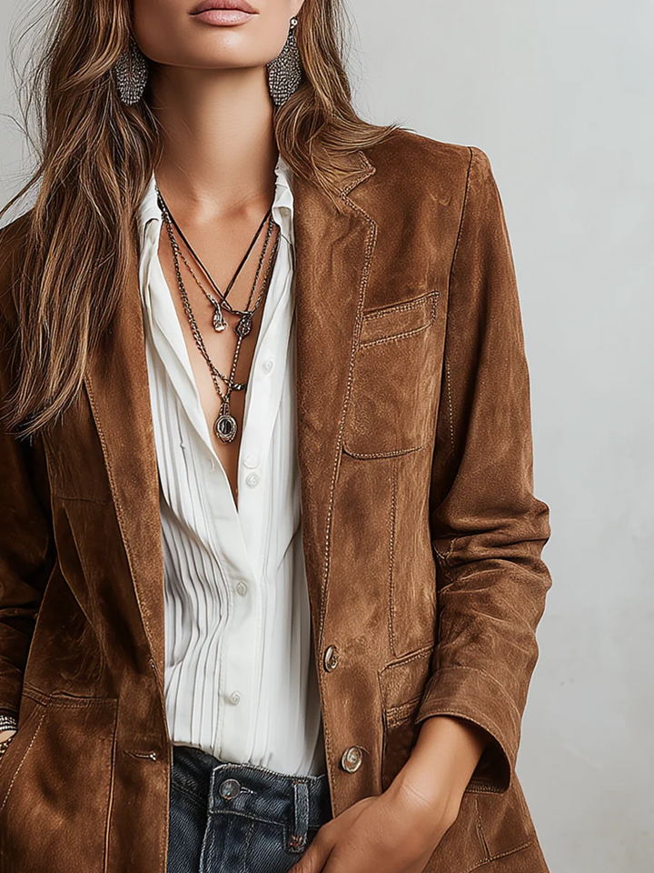 Detail of the single button closure and lapels on the brown blazer