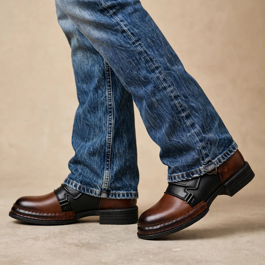 Man walking in two tone ankle boots with buckle straps and relaxed blue jeans