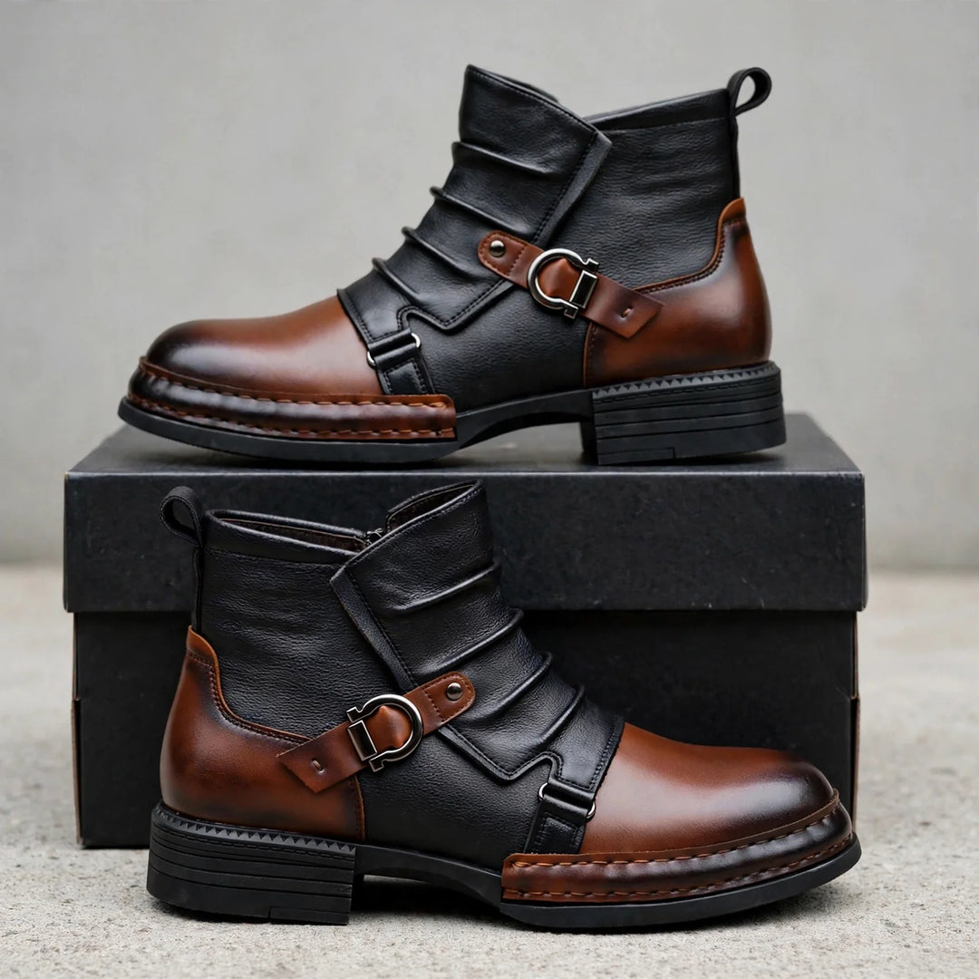 Pair of black and brown buckle strap boots displayed on a black box