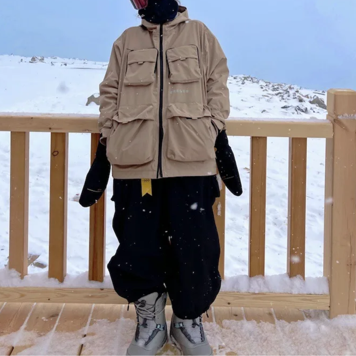 Snowboarder wearing the black wide leg snow pants on a wooden deck