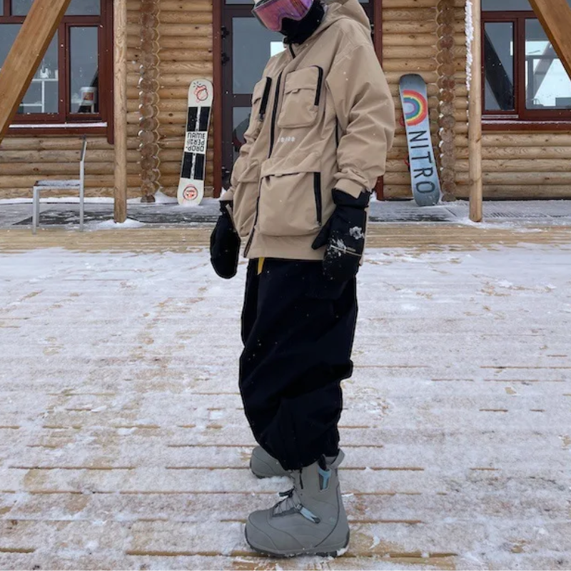 Black baggy ski pants worn with snow boots outside a mountain cabin