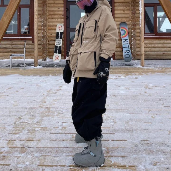 Black baggy ski pants worn with snow boots outside a mountain cabin
