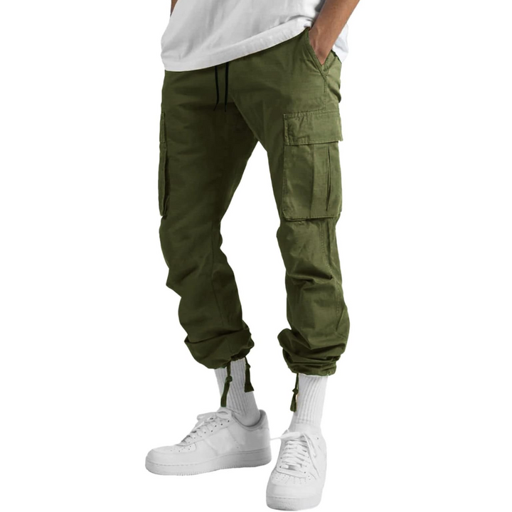 Army green cargo pants with hems cinched above white sneakers