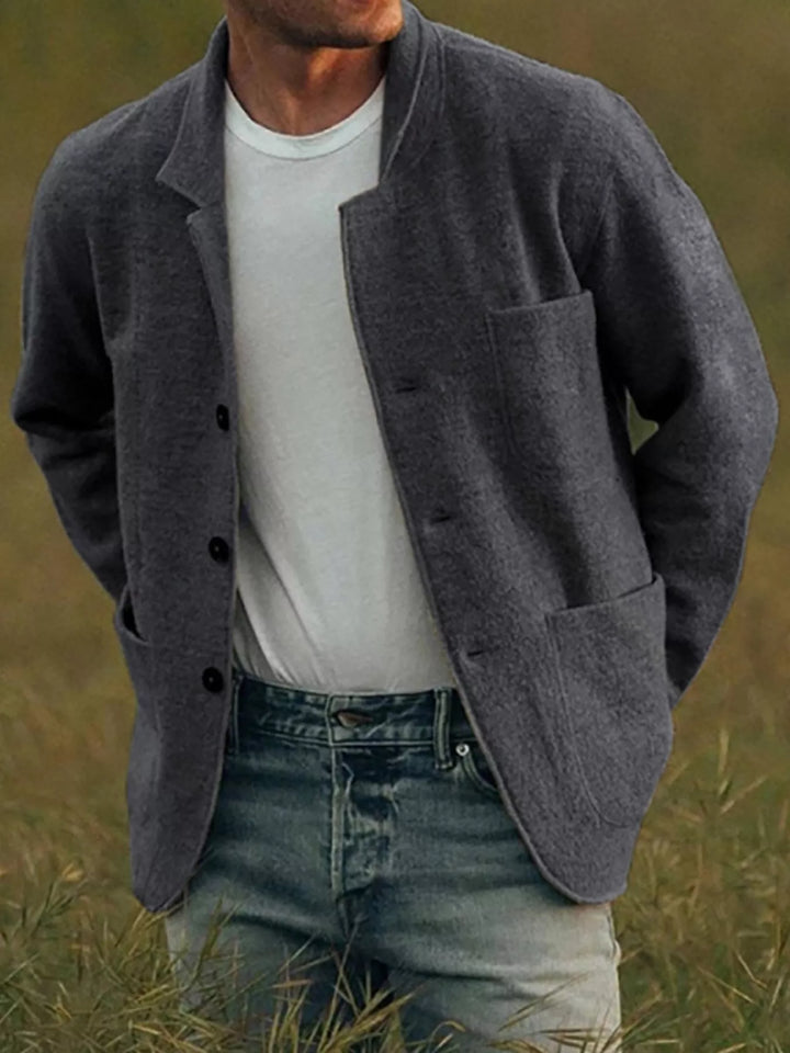 Dark gray textured blazer worn open, showing the hip and chest pockets