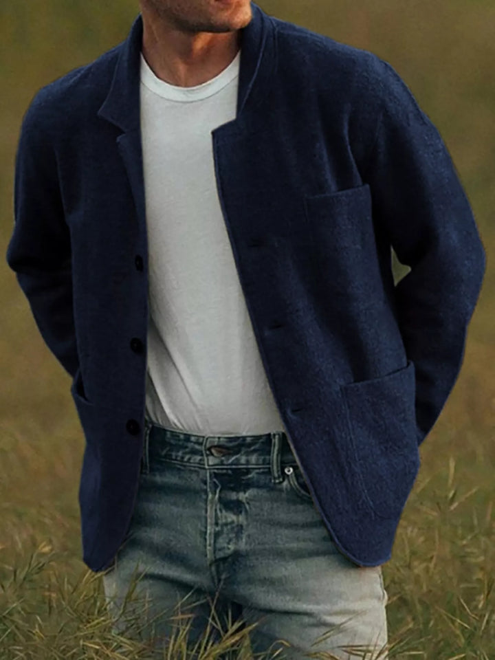 Navy sport coat with rounded front hem and patch pockets worn with a white tee