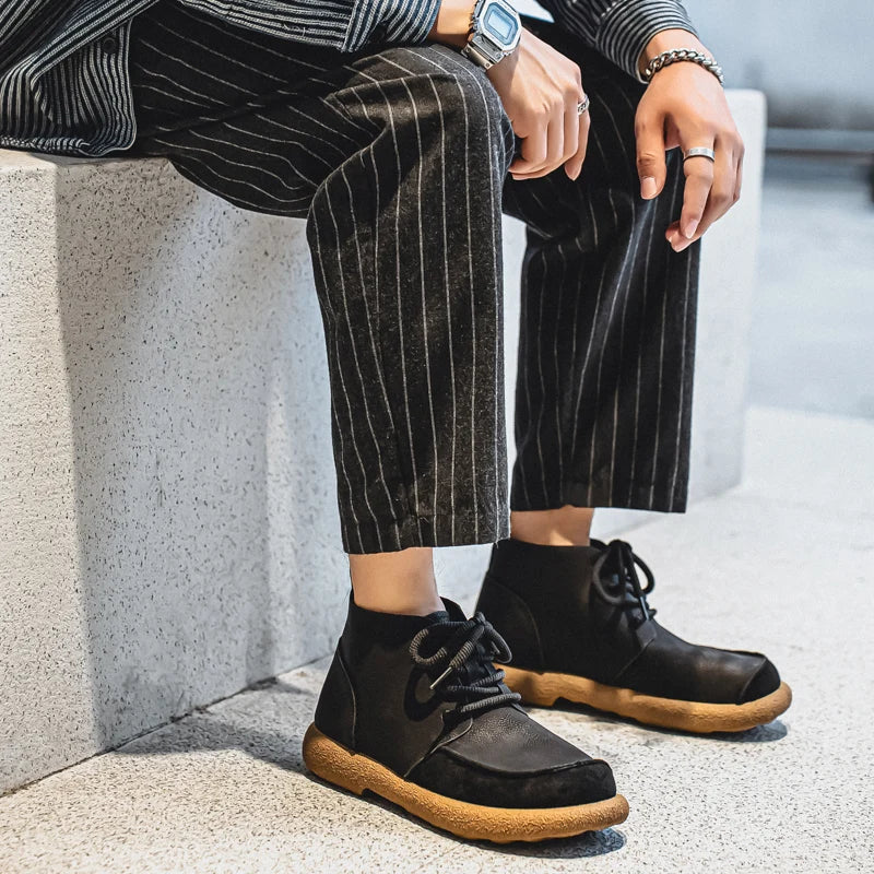 Black lace up ankle boots worn with striped trousers