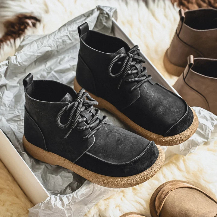 Pair of black lace up ankle boots on silver paper