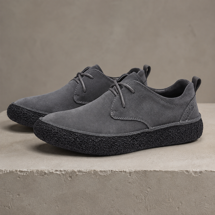 Pair of ash gray suede look low top shoes with black crepe sole