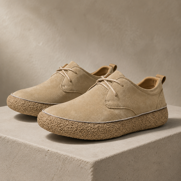 Pair of sand colored suede look low top shoes with crepe sole on a block