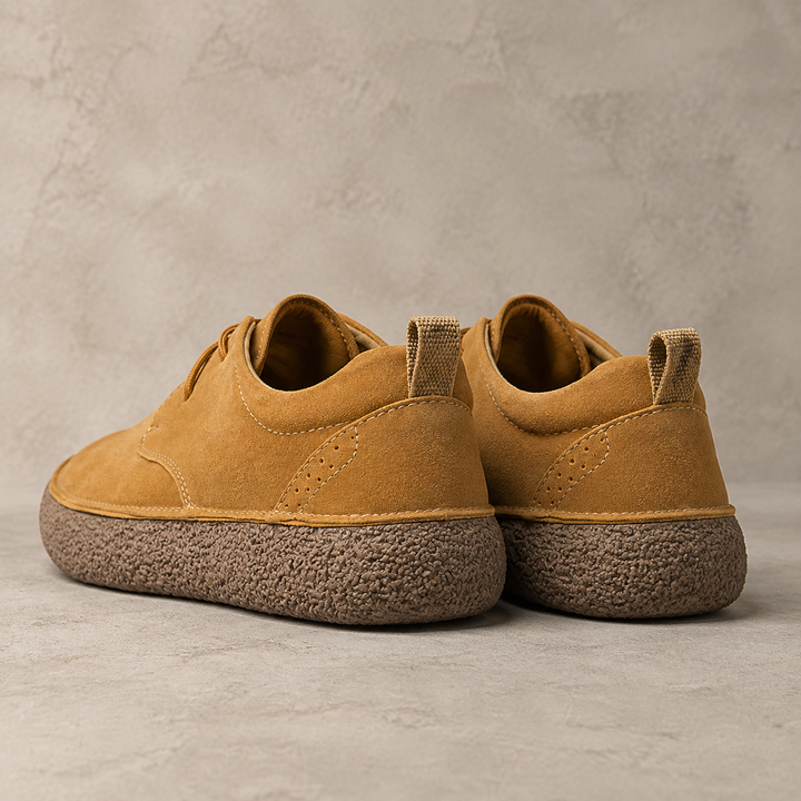 Back view of a pair of tan low top shoes with heel pull tabs