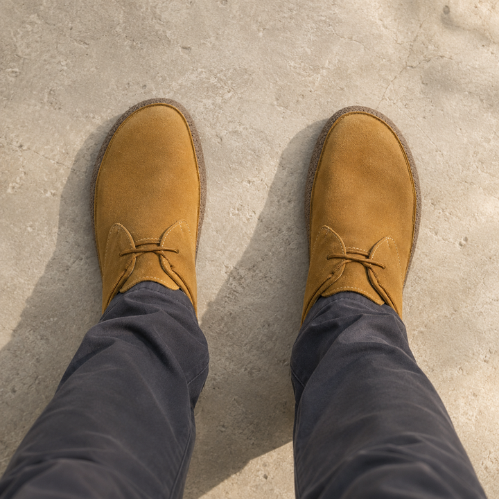 Tan suede look shoes worn with dark gray pants, view from above
