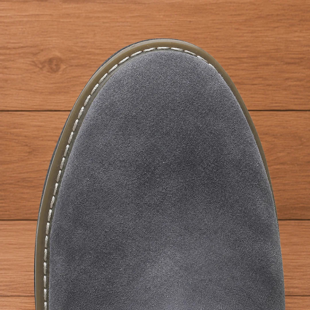 Close-up of the rounded toe and welt stitching on the gray boot