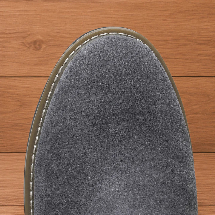 Close-up of the rounded toe and welt stitching on the gray boot