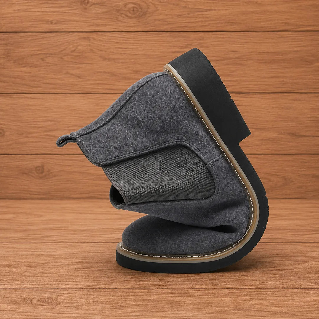 Dark gray chelsea boot bent to show how flexible it is