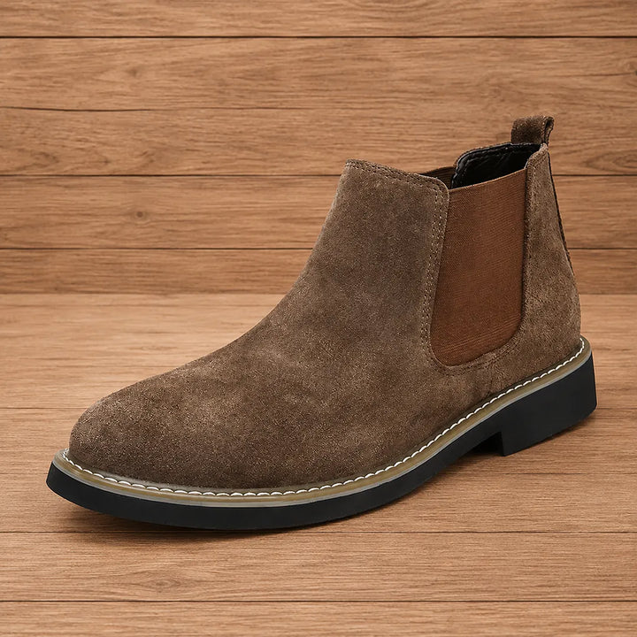 Taupe suede look chelsea boot with brown elastic gusset on a wood surface