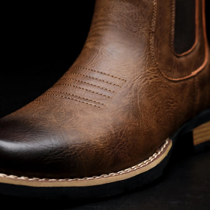 Close-up of the brown boot toe with decorative stitching and burnished finish