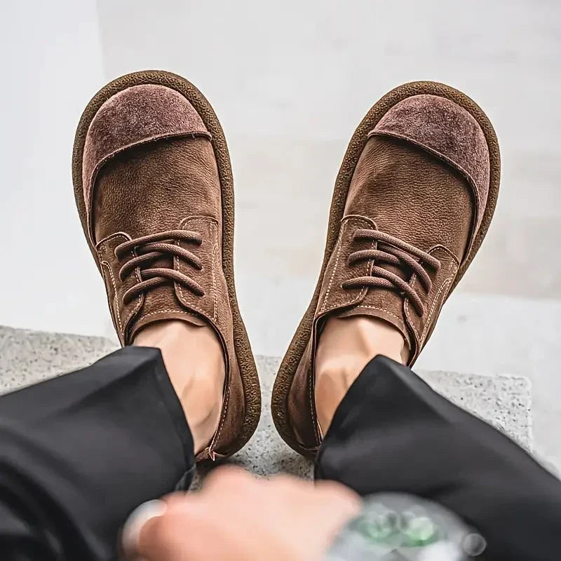 Brown wide toe lace up shoes worn with black trousers, seen from above