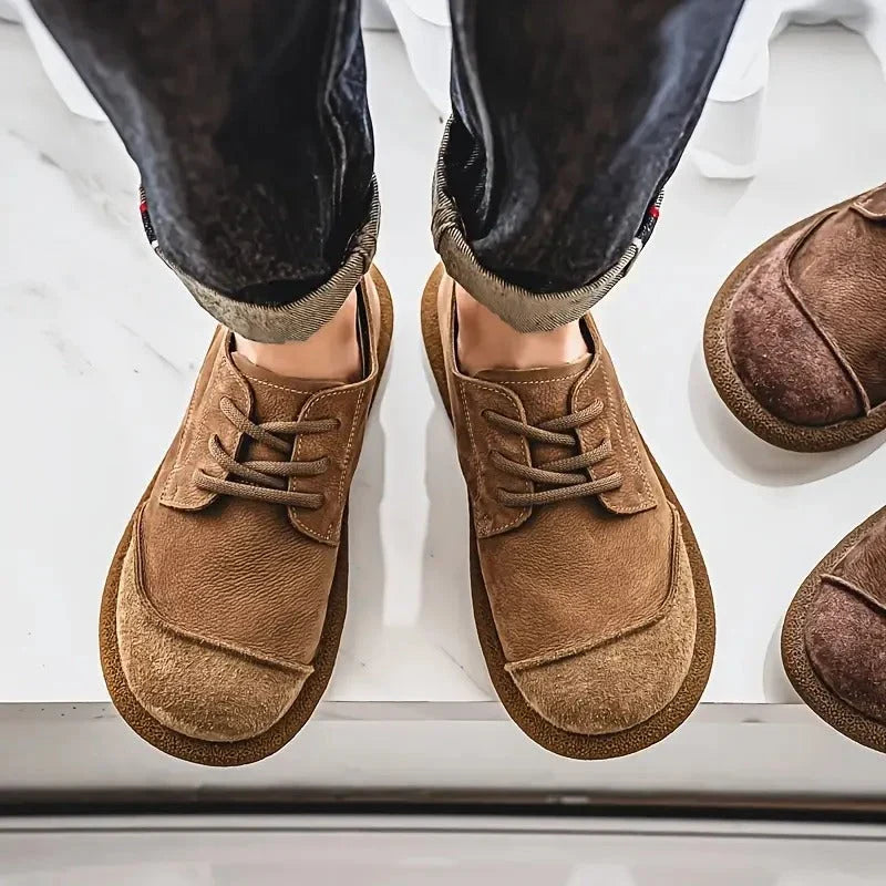 Tan wide toe lace up shoes worn with jeans, seen from above