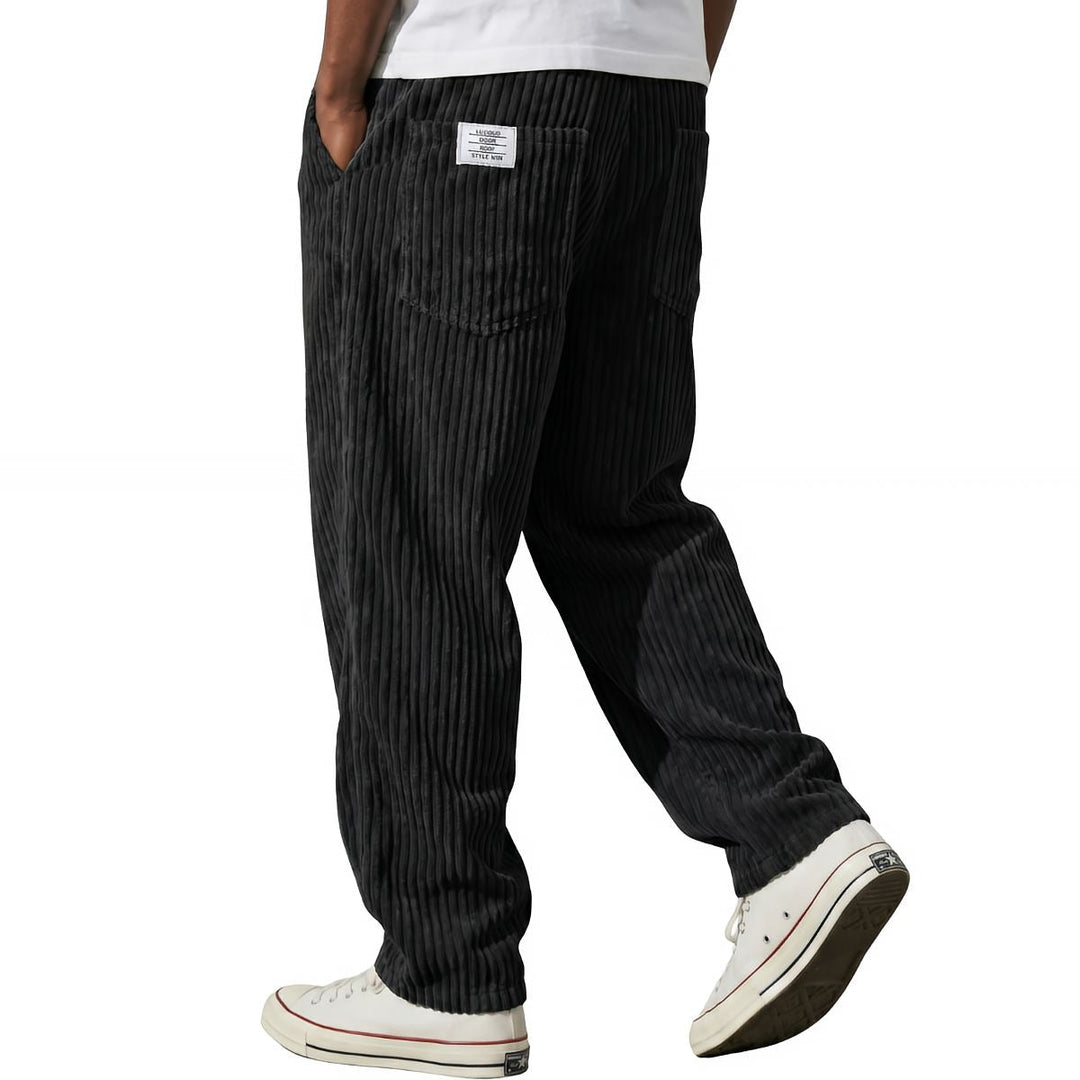 Black corduroy pants, relaxed straight leg, walking side view