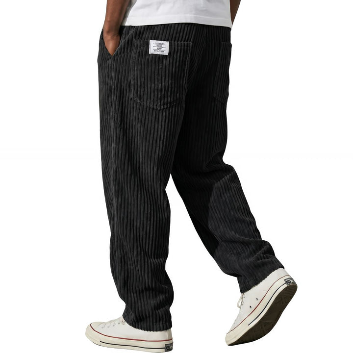 Black corduroy pants, relaxed straight leg, walking side view