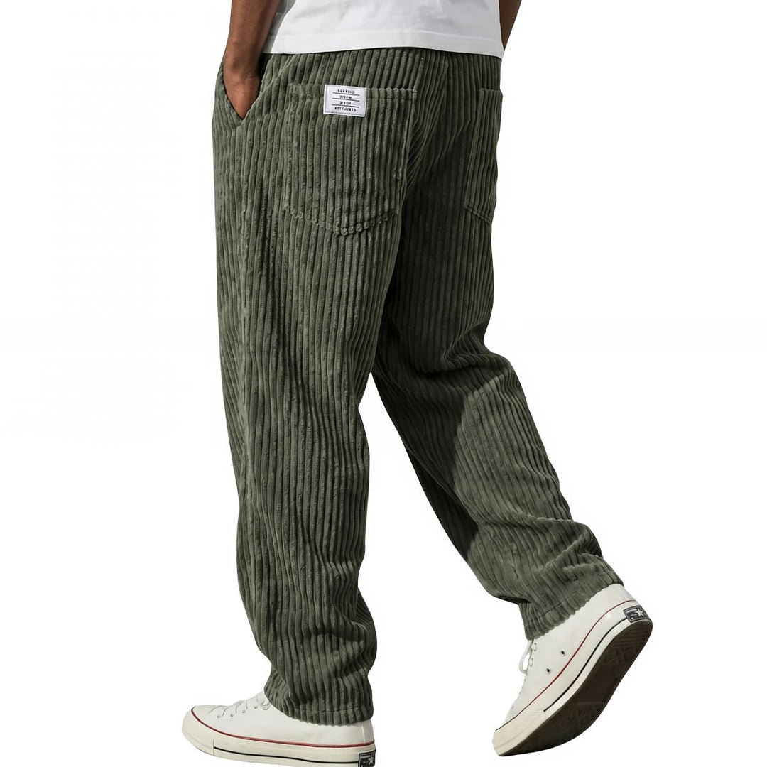 Dark green corduroy pants styled with white sneakers, side view