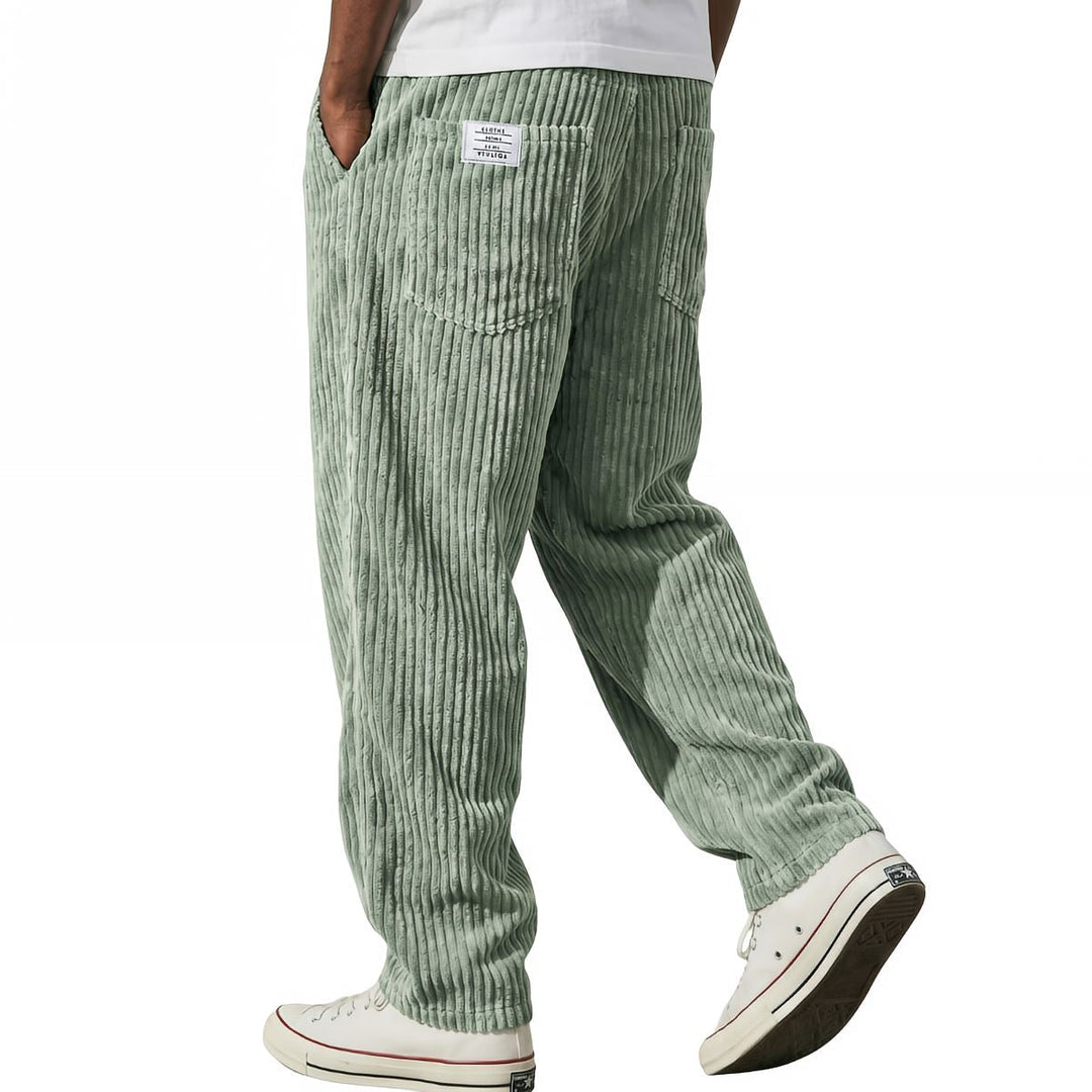 Sage green corduroy pants, relaxed fit, shown mid stride