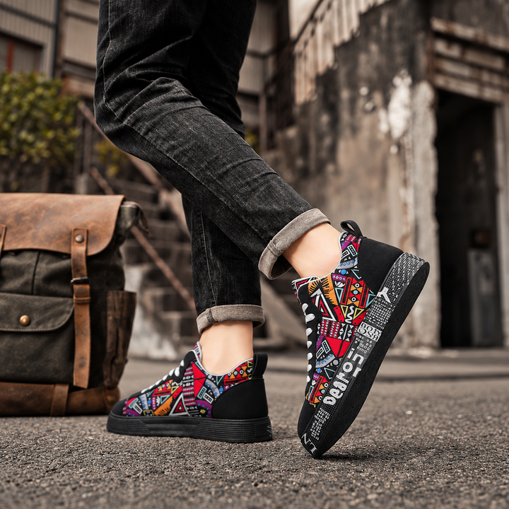Black graphic print sneakers worn with cuffed dark jeans on a city street
