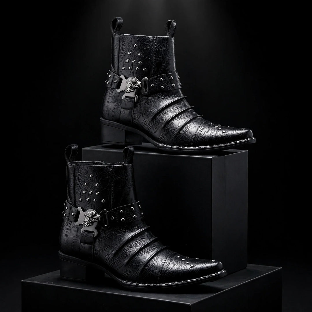 Pair of black harness ankle boots staged on dark blocks