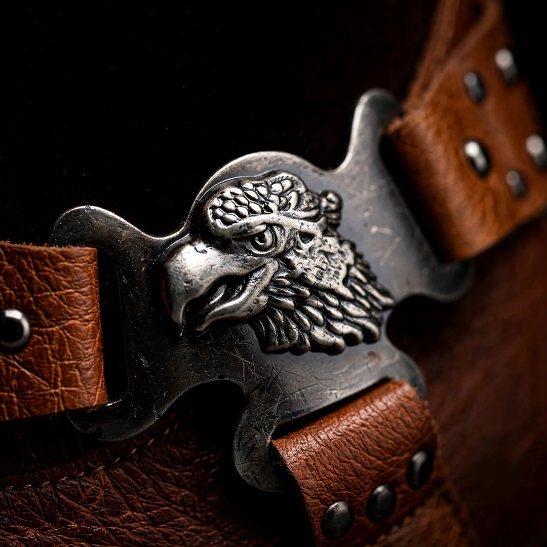 Close-up of the eagle head buckle on a brown leather strap