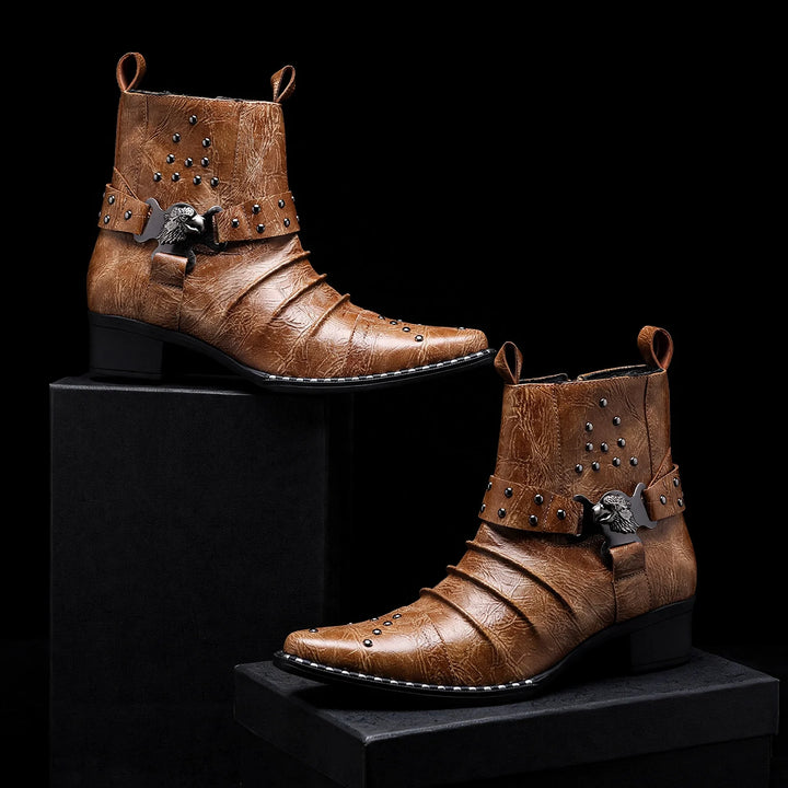 Pair of cognac ankle boots displayed on black blocks, studded harness detail
