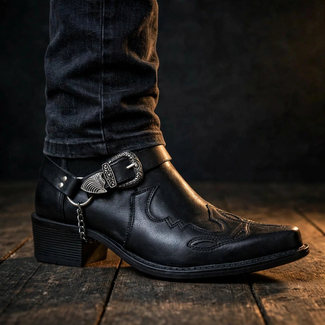 Black pointed toe cowboy boot worn with dark jeans