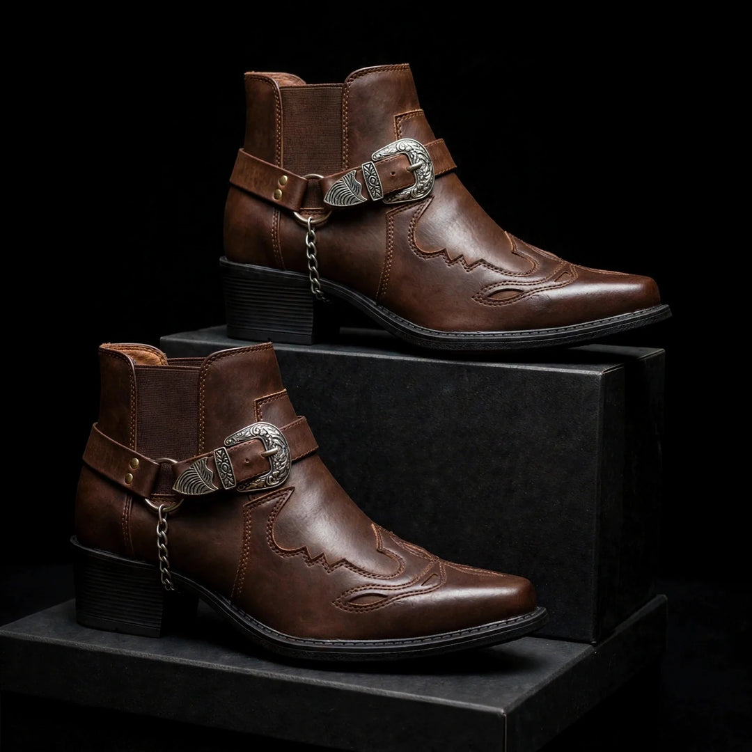 Two dark brown harness ankle boots displayed on black blocks