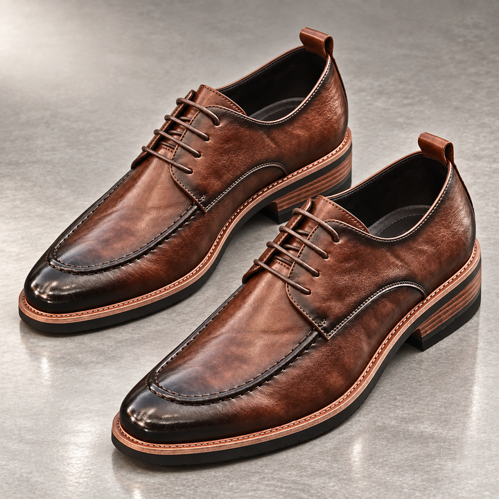 Pair of brown derby shoes with stacked heel and contrast sole on a gray floor