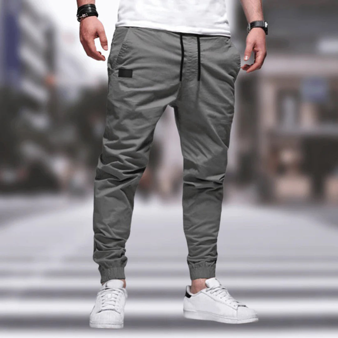 Men's gray drawstring cargo joggers, front view on a model