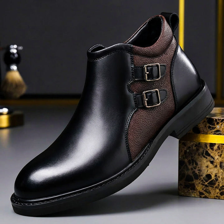 Black ankle boot with two buckle straps on a brown textured panel