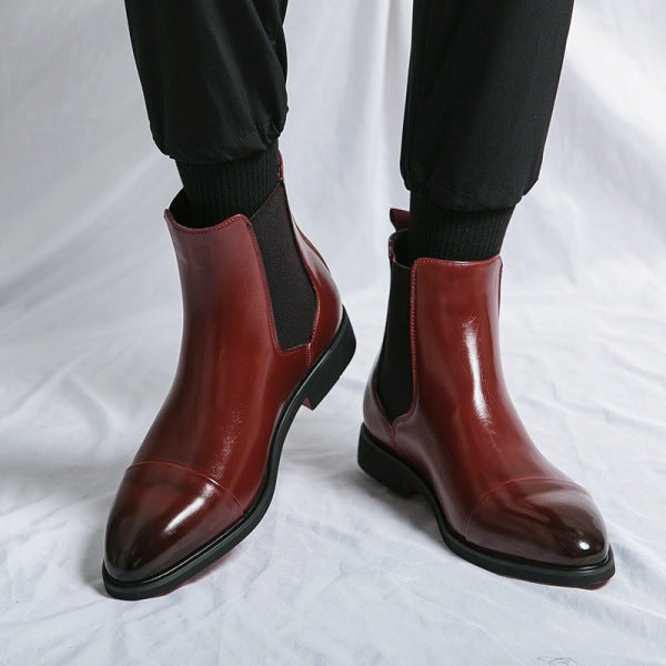 Burgundy dress chelsea boots worn with black pants, front three-quarter view