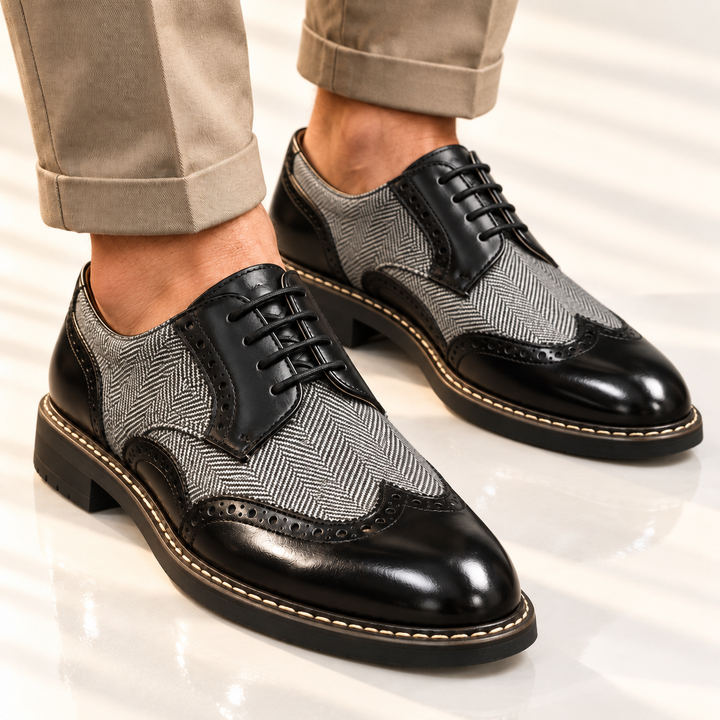Black brogue dress shoes worn with beige pants, angled front view