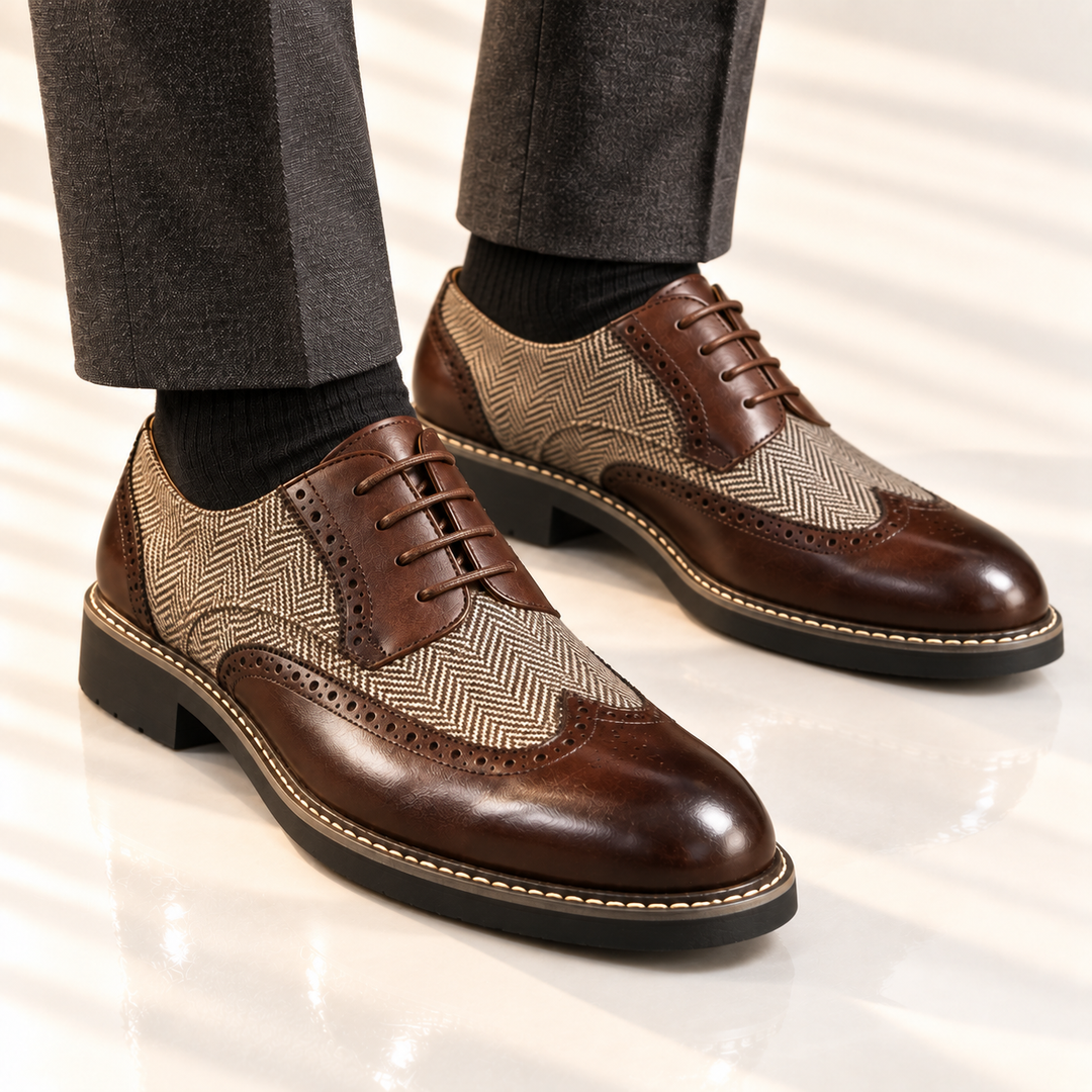 Brown wingtip dress shoes worn with gray trousers and black socks