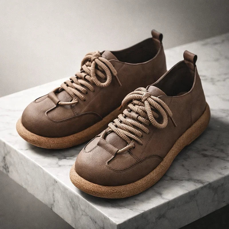 Taupe wide toe lace up sneakers angled on a marble block