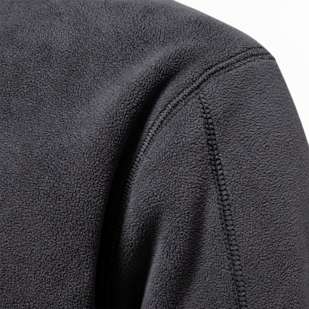 Close-up of the charcoal fleece shoulder seam and soft pile texture