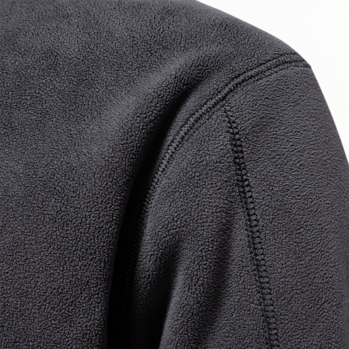 Close-up of the charcoal fleece shoulder seam and soft pile texture
