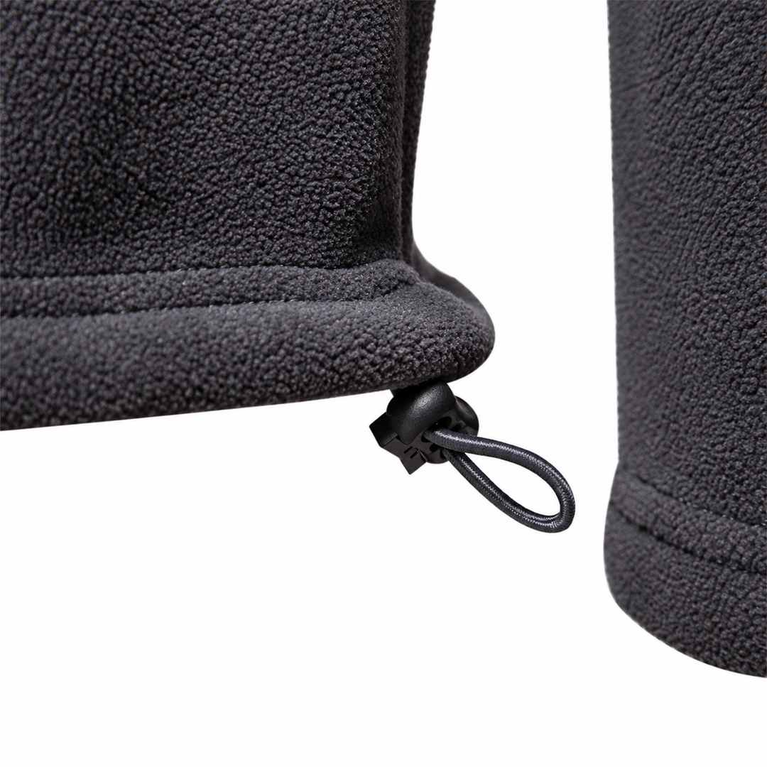 Detail of the drawcord and toggle at the hem of the charcoal fleece